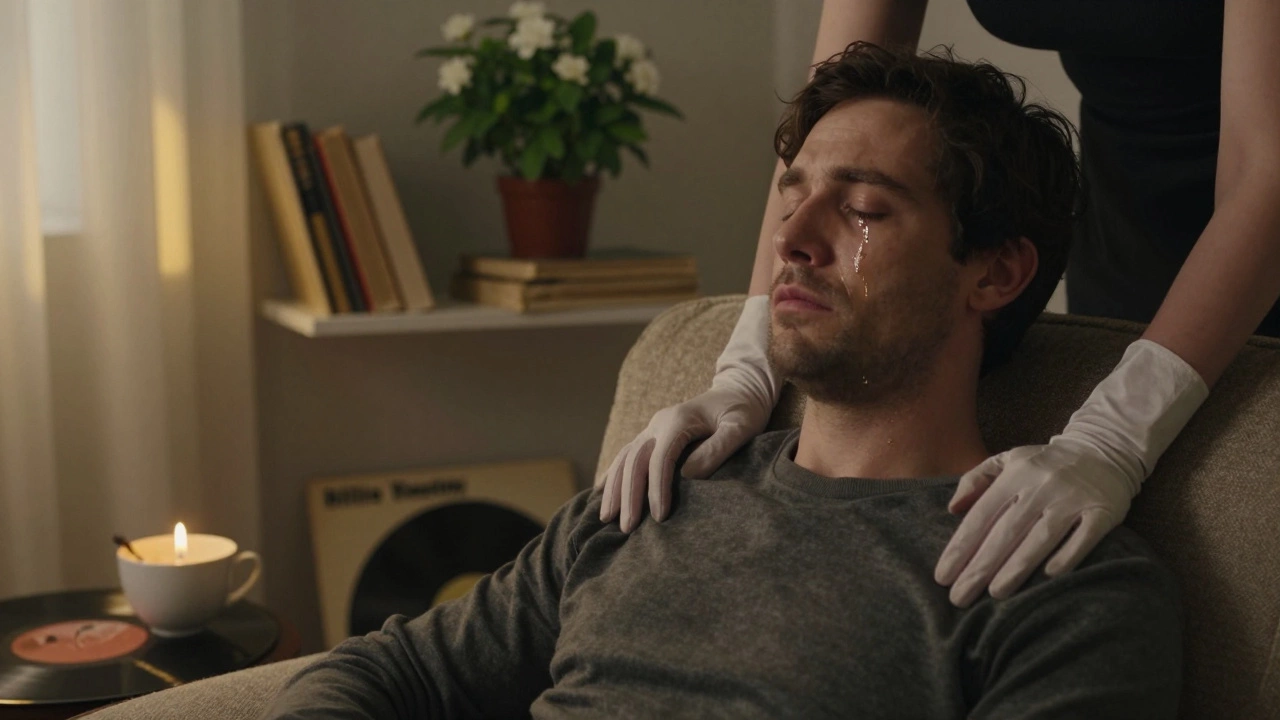 A woman&#039;s bare hands rest on a man&#039;s shoulders as he weeps silently, candlelight illuminating the intimate moment.